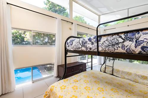 1 dormitorio con 2 literas y ventanas en Costa Rica Mango Villa, en Coyolar