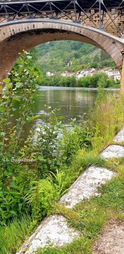 a bridge over a river with a body of water at La Buguoise in Le Bugue