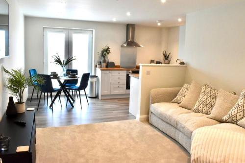 uma sala de estar com um sofá, uma mesa e uma cozinha em *Penthouse Luxury Apartment 2min to City em Carlisle