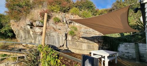 a patio with a table and an umbrella at Coastal Chic in Pohara in Pohara