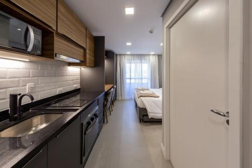 een keuken met een wastafel en een bed in een kamer bij BHomy Pinheiros - 700m do metrô F Lima RIZ216 in Sao Paulo
