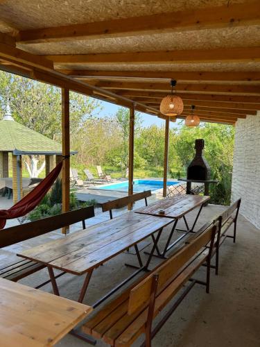 - un groupe de tables de pique-nique sur une terrasse avec une piscine dans l'établissement Casa Bella Fruška Gora, à Velika Remeta