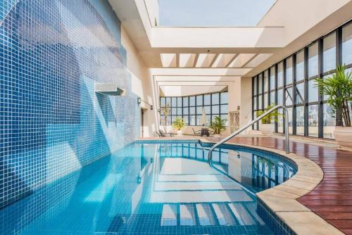 a swimming pool in a building with a swimming poolvisorvisor at BHomy Jardins Charme e estilo HB1911 in São Paulo