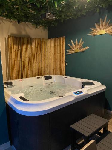 une baignoire jacuzzi dans une chambre avec une table dans l'établissement Nosy Komba Spa, à Carvin