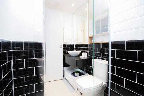 een zwart betegelde badkamer met een toilet en een wastafel bij BHomy Jardins Décor moderna ótimo local AD1301 in Sao Paulo
