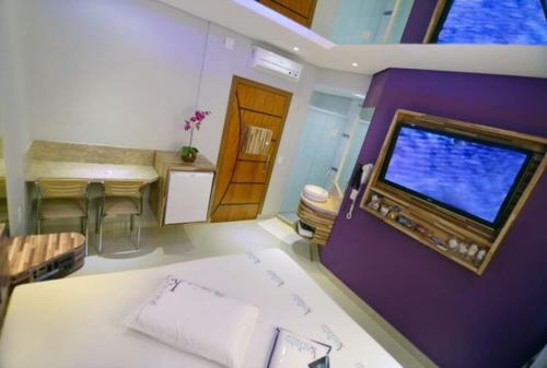 サントアンドレにあるKarinho Hotelの紫の壁のリビングルーム(薄型テレビ付)