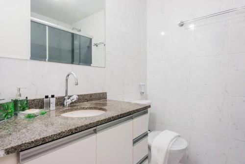 La salle de bains blanche est pourvue d'un lavabo et de toilettes. dans l'établissement BHomy Anhembi Excelente localização AB132A, à São Paulo