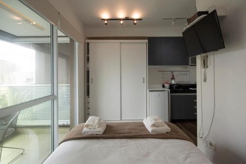 a bedroom with a bed with two towels on it at BHomy Turiassu in Sao Paulo