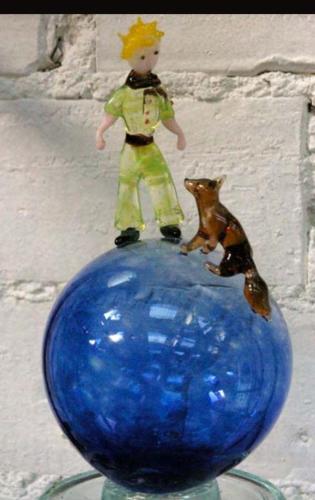 a toy doll and a dog on top of a blue vase at La Buguoise in Le Bugue