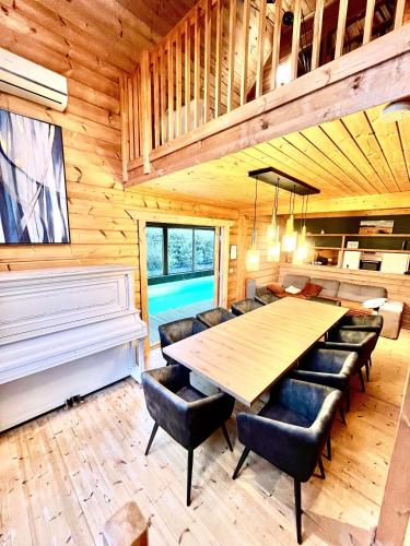 une salle à manger avec une table et un piano dans l'établissement Les Villas d' Onalou Port Blanc, à Penvénan