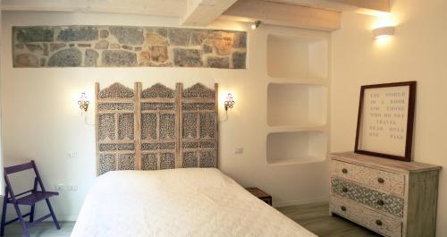 um quarto com uma cama, um espelho e uma cómoda em B&B Terra - Stanza Viaggio em Carloforte