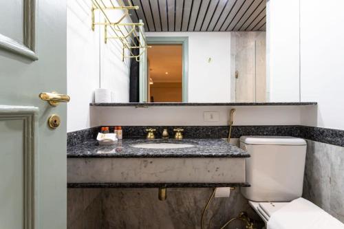 uma casa de banho com um lavatório, um WC e um espelho. em BHomy Jardins Para chamar de seu MD21 em São Paulo
