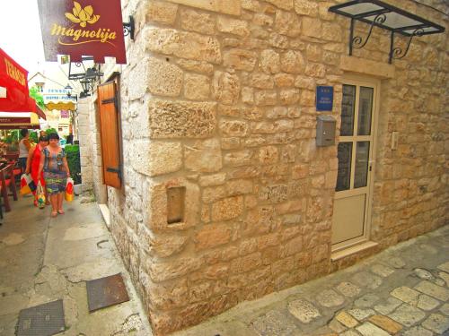 a stone building with people walking down a street at Studios Magnolia in Trogir