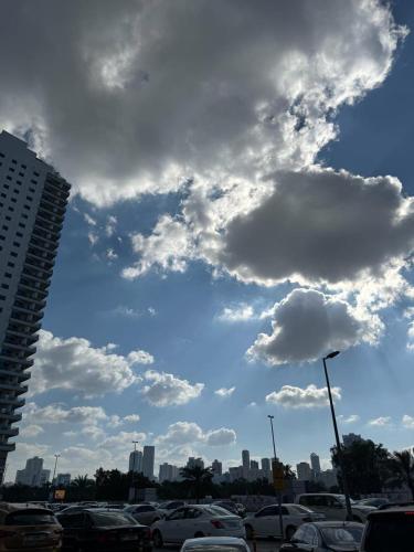 a cloudy sky with cars parked in a parking lot at MIRA ALMAJAZ in Sharjah