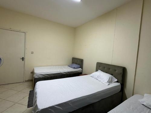 a room with two beds in it with a door at MIRA ALMAJAZ in Sharjah