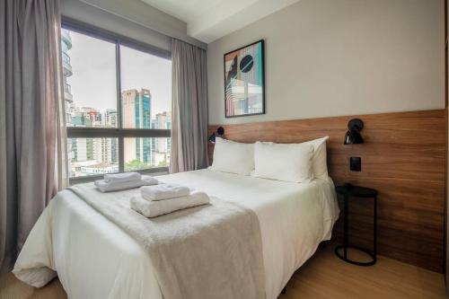 een slaapkamer met een groot bed en handdoeken bij BHomy V Nova Conceição - Moderno e novo NX1017 in Sao Paulo