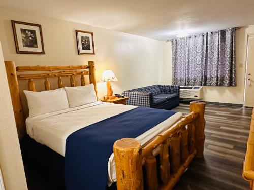 a bedroom with a large bed with a blue blanket at Northwoods Motel in Blaine