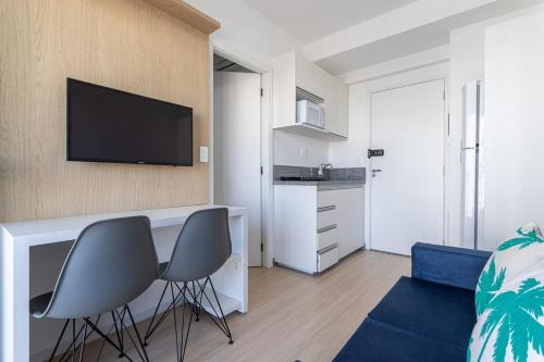 a living room with two chairs and a television on a wall at BHomy V Nova Conceicao - Suíte e varanda NX1409 in Sao Paulo