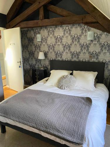 een slaapkamer met een groot wit bed met een muur bij MAS DE JOUAS Rocamadour in Saint-Rémy