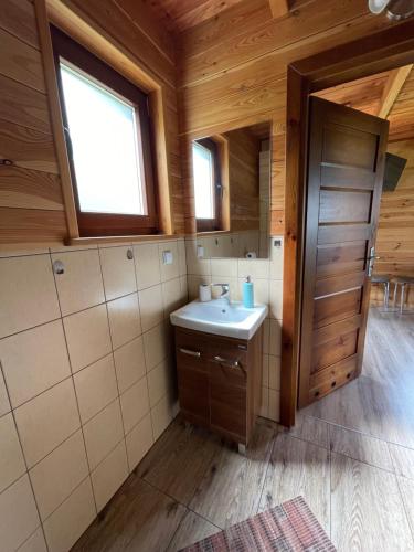 a bathroom with a sink in a wooden house at Domki Za Górą in Jazowsko