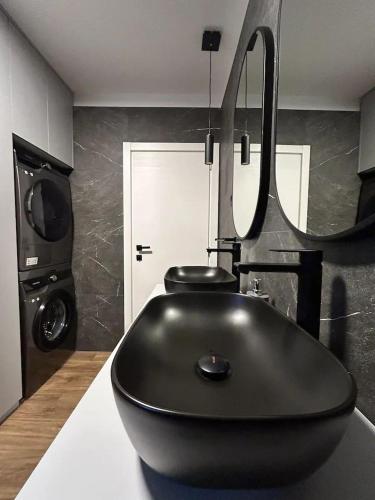a bathroom with a black bath tub in a room at Apartment Aria in Lovran