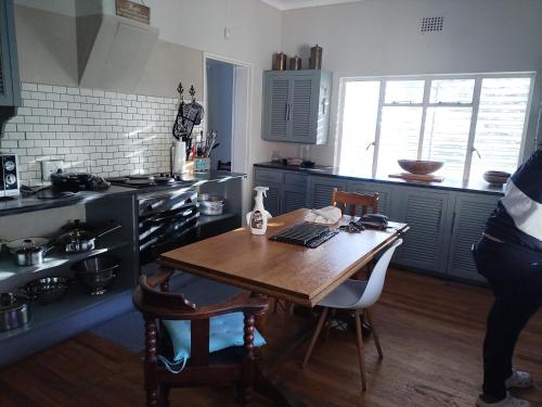 a kitchen with a wooden table with a laptop on it at Uitzight in Beaufort West