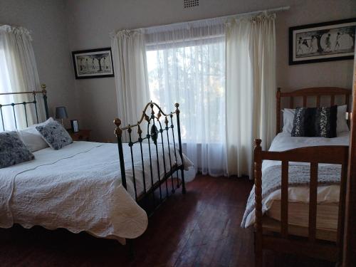 een slaapkamer met 2 bedden en een raam bij Uitzight in Beaufort West