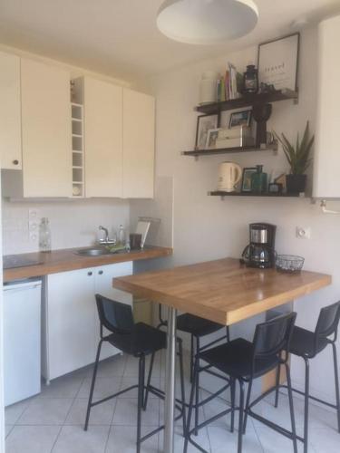 une cuisine avec une table et des chaises en bois dans l'établissement Petite maison de pêcheur au coeur d'Etretat, à Étretat