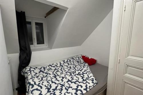 Cette petite chambre dispose d'un lit et d'une fenêtre. dans l'établissement Petite maison de pêcheur au coeur d'Etretat, à Étretat