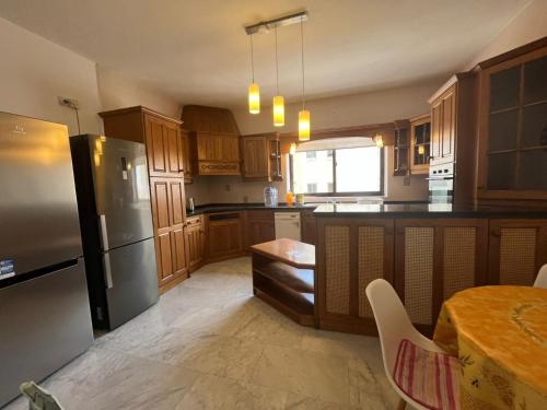 a kitchen with wooden cabinets and stainless steel appliances at XL Spacious Apartment, 4-BR Home in Central Area, WALK to Sliema - St Julian's in Il-Gżira