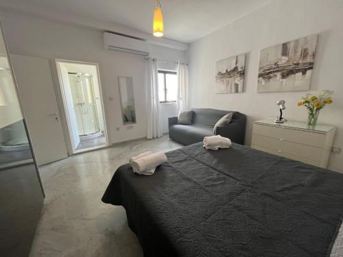 a living room with a bed and a couch at XL Spacious Apartment, 4-BR Home in Central Area, WALK to Sliema - St Julian's in Il-Gżira