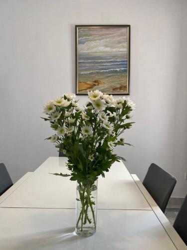 a vase of white flowers sitting on a table at XL Spacious Apartment, 4-BR Home in Central Area, WALK to Sliema - St Julian's in Il-Gżira
