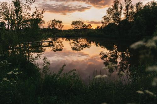 ein Spiegelbild des Himmels in einem Teich bei Sonnenuntergang in der Unterkunft Poganty - Jałownik in Giżycko