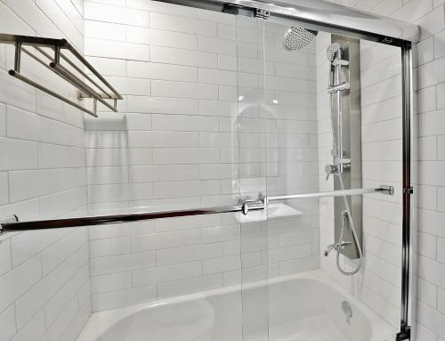 une douche avec une porte en verre et une baignoire dans l'établissement 35#23 Chemin du Hameau, à Stoneham