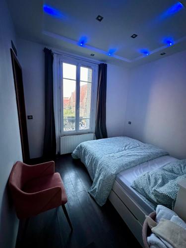 - une chambre avec un lit et une fenêtre avec des lumières bleues dans l'établissement Appartement Loft Lumière T2 à Ivry-sur-Seine, à Ivry-sur-Seine
