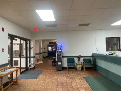 an empty waiting room with chairs and a desk at Dakota Inn in Minot