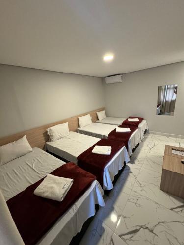 a row of beds in a room with marble floors at Hotel Fênix Belenzinho in Sao Paulo