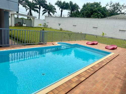 a swimming pool with blue water in a yard at Sci h in Douala