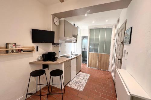 - une cuisine avec deux tabourets et un comptoir avec un évier dans l'établissement Old Antibes - 2 people, à Antibes