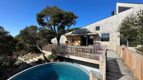 a house with a swimming pool in front of a house at Portsea Shingle House in Portsea