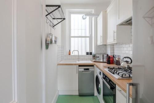a kitchen with white cabinets and a green floor at The Highlife Holborn in London