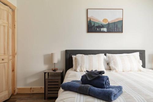 a bed with a blue blanket on top of it at Pondview 4BR Cabin-Walk to Caverns, Hot Tub, Wi-Fi in Luray