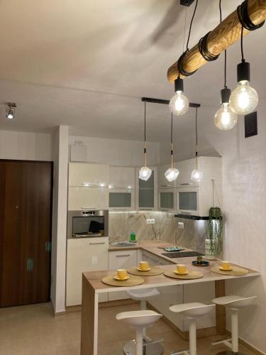 uma cozinha com mesa, cadeiras e luzes em APART NOSAL em Zakopane