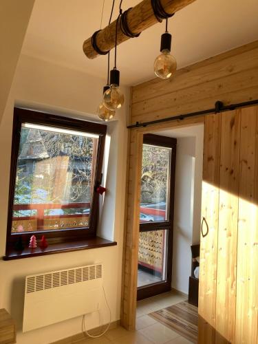 um quarto com 2 janelas e uma ventoinha em APART NOSAL em Zakopane