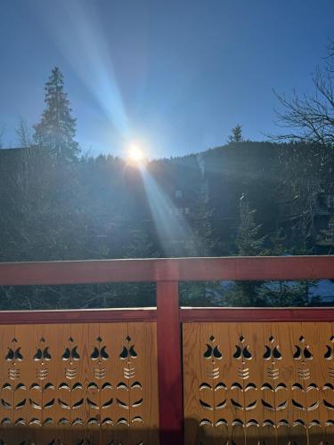 een uitzicht op de zon die opkomt achter een houten hek bij APART NOSAL in Zakopane