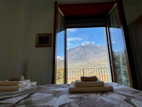 a bedroom with a large window with a view of a mountain at Residenza Alba (intero alloggio) in Caiolo