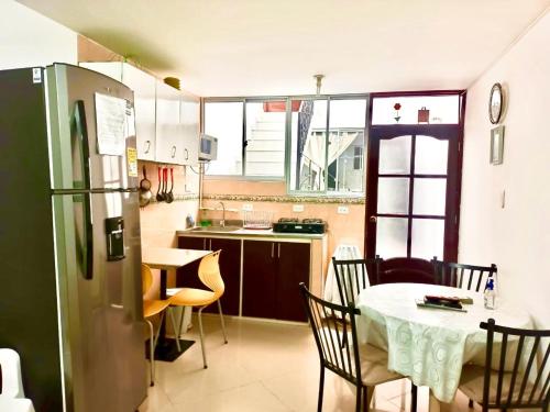 a small kitchen with a table and a refrigerator at Apartamento amoblado para alquiler temporal zona Norte in Pasto