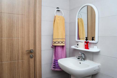 ein Bad mit einem Waschbecken und einem Spiegel in der Unterkunft studio mami in Tacape