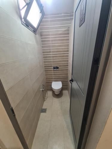 een kleine badkamer met een toilet en een deur bij studio mami in Gabès