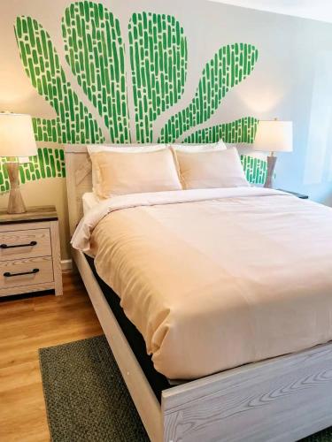 a bedroom with a white bed with a cactus wall at Hiker's Haven in Townsend